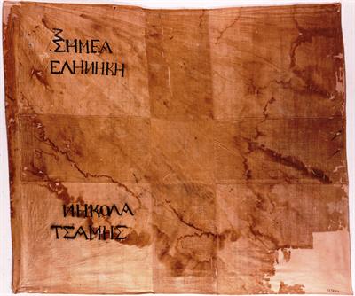 Flag of Macedonian Fighters of 1821. It bears the inscription: ΣΗΜΕΑ ΕΛΗΝΗΚΗ – ΝΗΚΟΛΑ ΤΣΑΜΗΣ (Greek flag – Nicholas Tsamis).