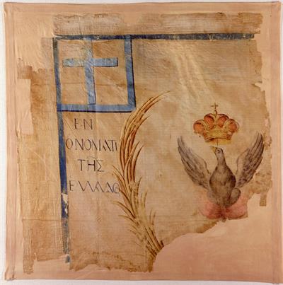 Part of a White Flag of the Ottonian period depicting a phoenix with a crown and a blue cross, 1833-1862. It bears the inscription: ΕΝ ΟΝΟΜΑΤΙ ΤΗΣ ΕΛΛΑΔΟΣ (In the Name of Greece).