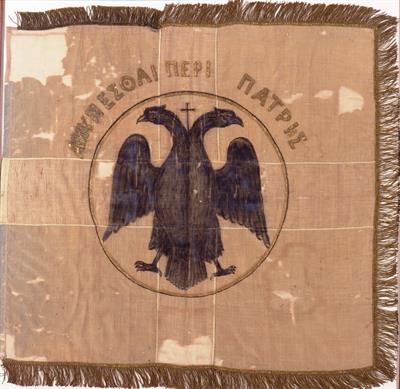 Κυανή σημαία με λευκό σταυρό, δικέφαλο αετό στο κέντρο και την επιγραφή: ΑΜΥΝΕΣΘΑΙ ΠΕΡΙ ΠΑΤΡΗΣ. Ανήκε στον οπλαρχηγό του Μακεδονικού Αγώνα Ηλία Δεληγιαννάκη, αξιωματικό που έπεσε στη μάχη του Σκρα το 1918.