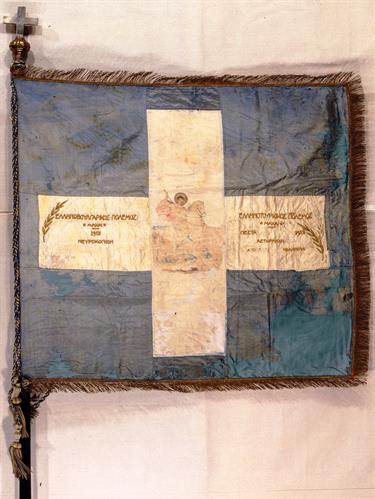 Blue and White war flag of the 7th Evzones Battalion. It bears a representation of St. George in the center of the cross and inscriptions.