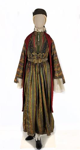 Γυναικεία φορεσιά από το Ζαγόρι Ηπείρου. Αποτελείται από μεταξωτό πουκάμισο, ριγωτό μεταξωτό φόρεμα και γιλέκο διακοσμημένα με κεντήματα από μεταξωτά και χρυσά κορδόνια και μάλλινη φλοκάτα (επενδύτη) από μαύρο υφαντό διακοσμημένο με κόκκινα γαϊτάνια. Στο 