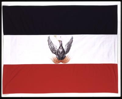 Αντίγραφο της τρίχρωμης σημαίας με το φοίνικα στη μία όψη και το σταυρό στην άλλη, την οποία ύψωσε ο Αλέξανδρος Υψηλάντης στο Ιάσι κατά την είσοδό του στις Παραδουνάβιες Ηγεμονίες, 22 Φεβρουαρίου 1821.