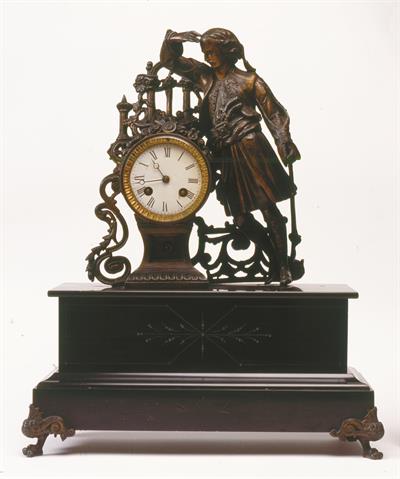 Γαλλικό επιτραπέζιο ρολόι με εκκρεμές, από πατιναρισμένο ορείχαλκο και μάρμαρο. Διακοσμείται με ολόσωμη μορφή Έλληνα αγωνιστή, α&#039; μισό 19ου αι.