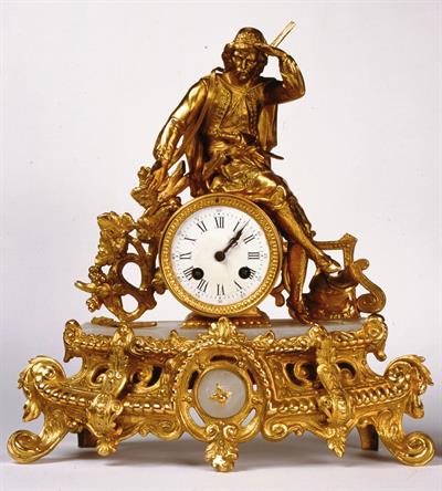 Επιτραπέζιο ρολόι με εκκρεμές. Φέρει φιλελληνική διακόσμηση με Έλληνα αγωνιστή σε θέση βιγλάτορα. Είναι κατασκευασμένο από τον οίκο S.Marti et Cie, και είναι βραβευμένο με MEDAILLE DE BRONZE, στη Διεθνή Έκθεση Βιομηχανικών Προϊόντων που έγινε το 1860.