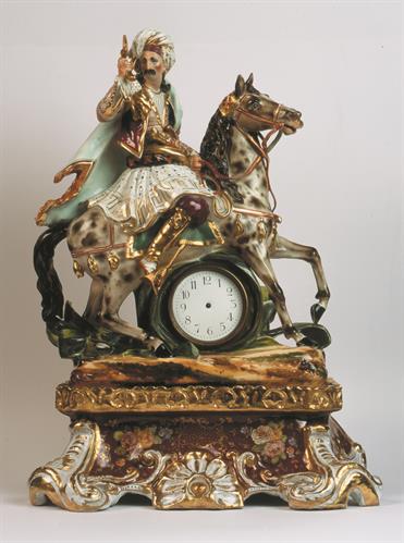 Γαλλικό επιτραπέζιο ρολόι με εκκρεμές, από πορσελάνη των αρχών του 19ου αι. Το θέμα διακόσμησής του θυμίζει το ομώνυμο με το ποιητικό έργο του Λόρδου Μπάυρον &quot;Giaour&quot;, έργο που σχεδίασε ο ζωγράφος Th. Gericault.