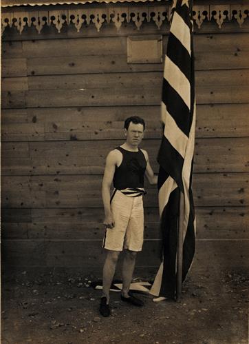 Olympic Games 1896. An athlete holding the flag of his country. Photograph.