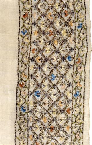 Νυφική πετσέτα από την Κωνσταντινούπολη διακοσμημένη με ρομβοειδή σχήματα ενωμένα μεταξύ τους με σταυρούς που περικλείουν ανθικά θέματα, δουλεμένα με χρυσές, ασημένιες και μεταξωτές κλωστές.